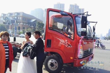 A Newly Wedded Couple Standing in Front of a CNHDT Wangpai Truck